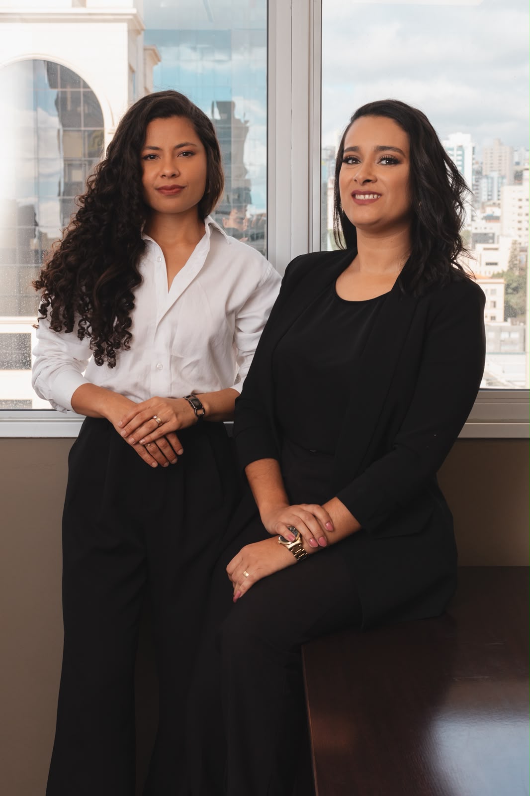 Ana Flávia Barbosa e Camila Miranda em frente à janela do escritório